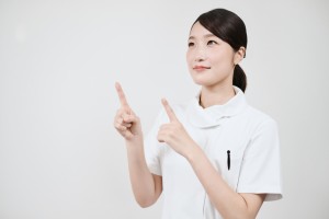 指差しをする白衣の女性