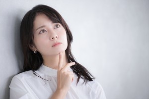 上を向いて眉間を寄せる女